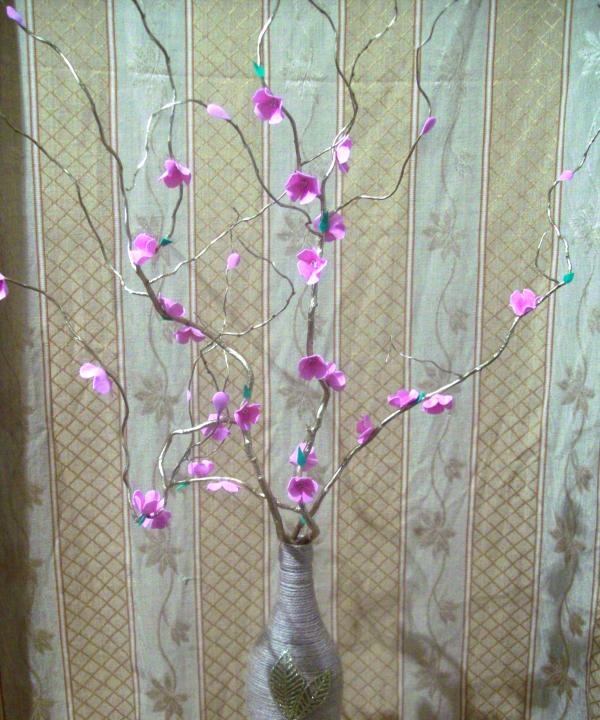 Jarrón con flores en una rama.