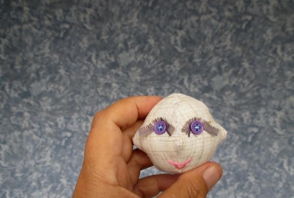 Sew on the doll's eyes