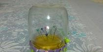 A pincushion made from a transparent jar