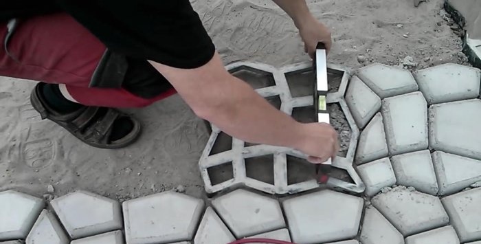 Doe-het-zelf bestrating van het terras met zelfgemaakte betontegels