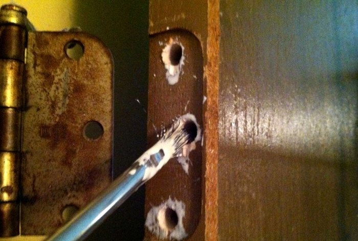 Restauració dels forats trencats per als cargols de frontissa de la porta