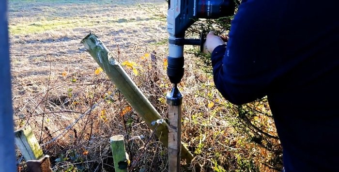 Hämmert Holzpfähle mit einem Bohrhammer