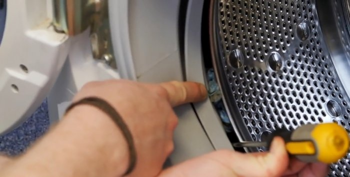 Hvordan fjerne små gjenstander som sitter fast bak trommelen fra en vaskemaskin