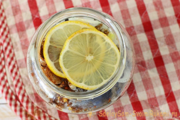 Arenque marinado em uma jarra com especiarias e limão