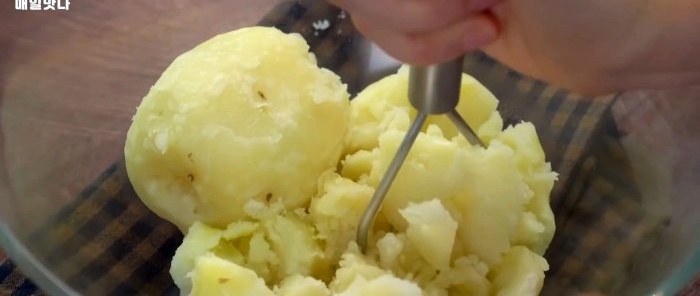 Kartoffeln kochen, schälen und mit einem Kartoffelstampfer zerstampfen