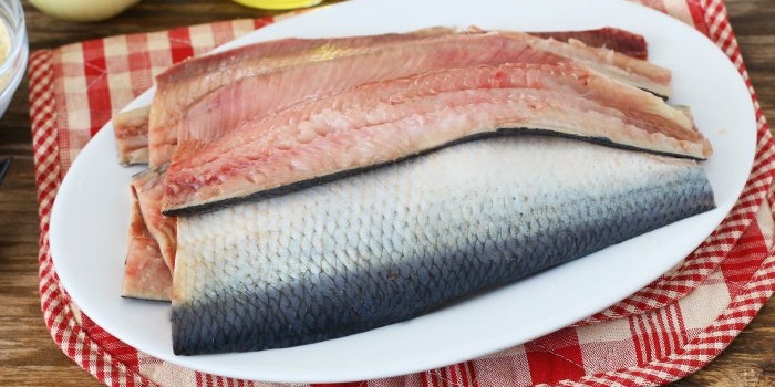 potong herring menjadi kepingan fillet tanpa tulang kecil dan besar