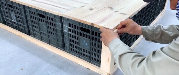 Bed made of plastic vegetable crates with numerous storage spaces