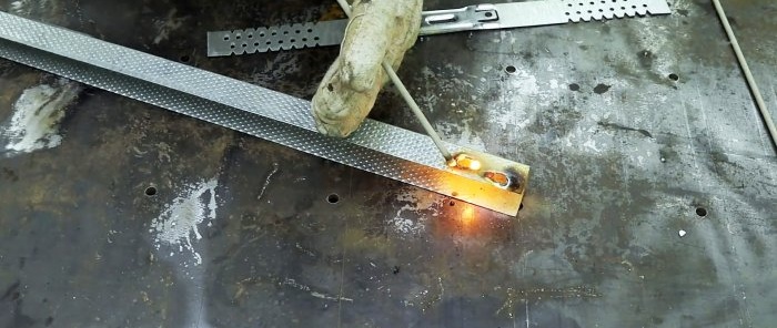 Vékony fém és csavarok hegesztése grafit rúddal akkumulátorról