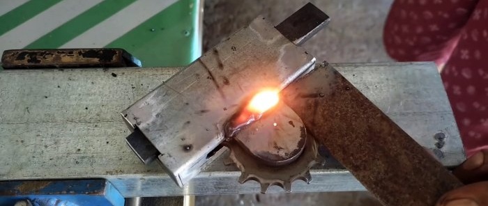 Pestillo de puerta con mando giratorio fabricado con materiales de desecho y piezas de motocicletas.